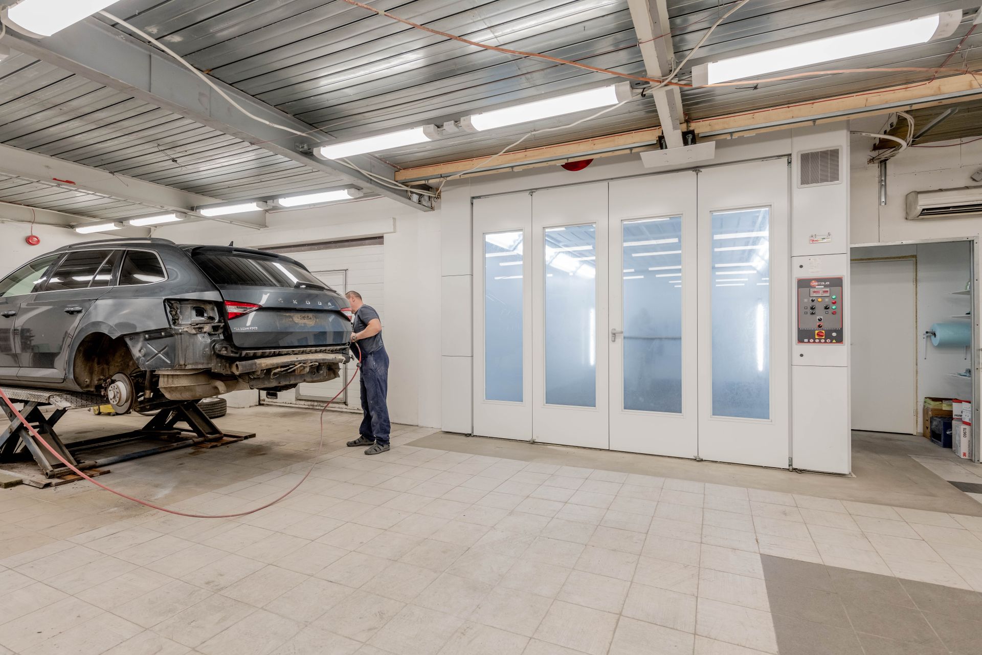 Mechanic working with a vehicle in a complete workshop scene